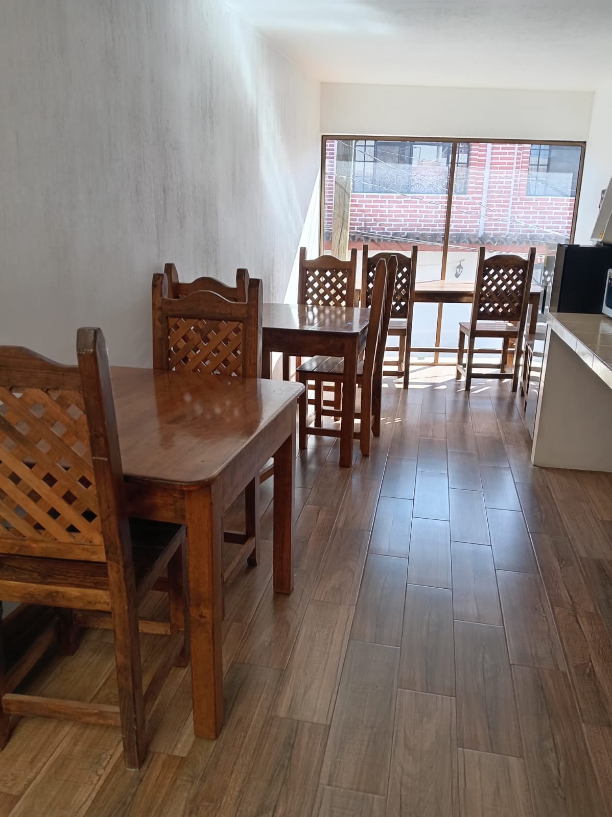 Área común de Hotel Bosques con mesas y sillas de madera